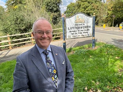 Commissioner standing by Lutterworth sign