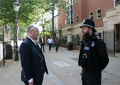 Commissioner standing on street talking to Police Officer